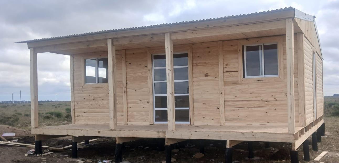 Frente de casilla de madera con aberturas de aluminio y puerta de chapa