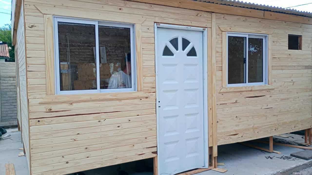 Vivienda de madera estilo cabaña con techo de chapa en un terreno