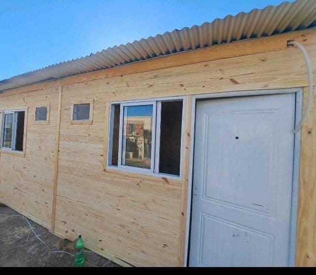 Casilla de madera con techo de chapa y ventanas de aluminio
