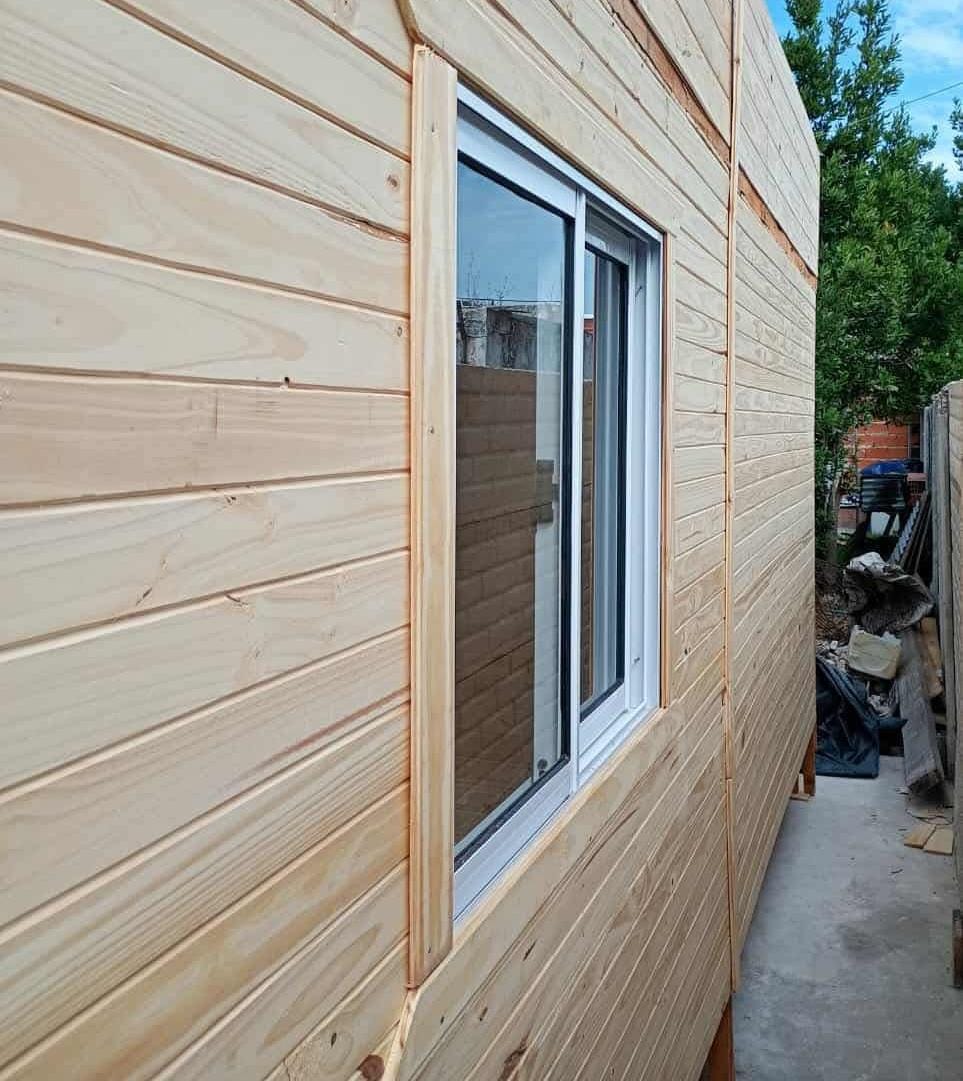 Interior cálido de una vivienda de madera con cielorraso claro